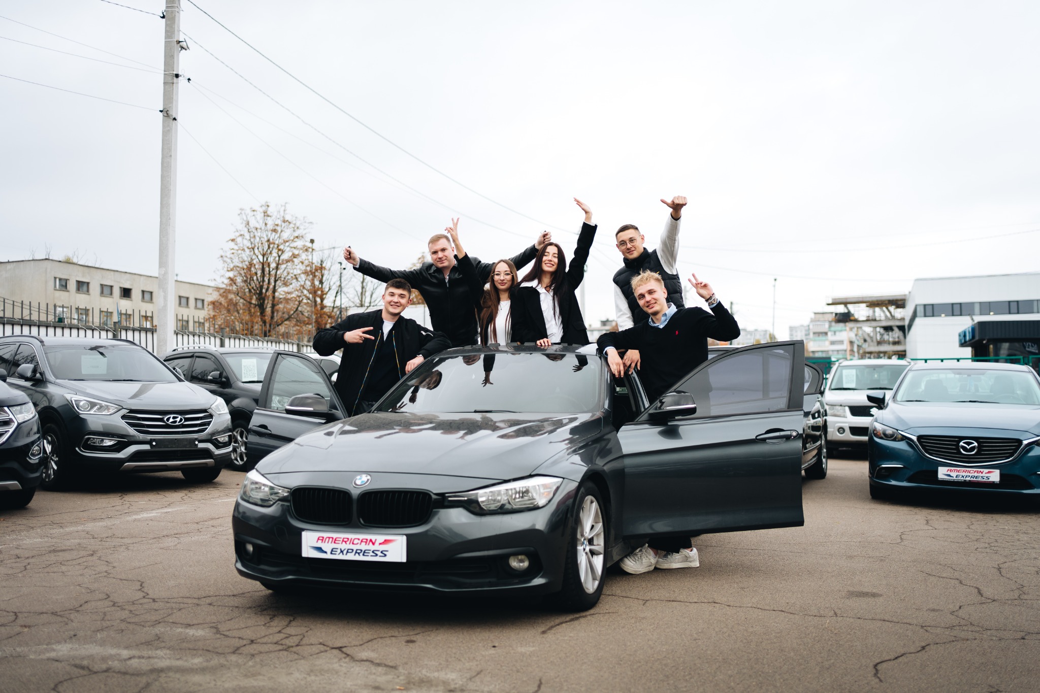 Команда American Express Auto біля автомобіля BMW